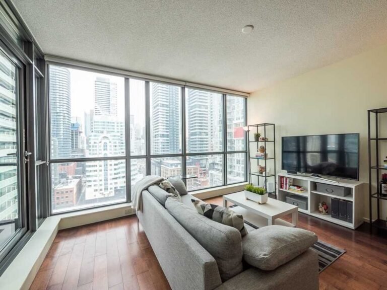 Condo living room with floor-to-ceiling windows and city views